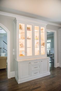 a white cabinet with glass doors and drawers