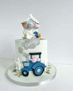 a three tiered cake decorated with farm animals and the word george on it's side