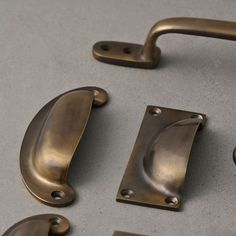 several brass handles and pulls on a gray surface