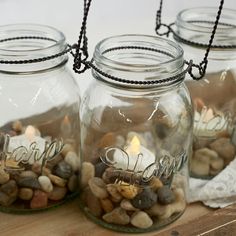 three mason jars filled with rocks and candles