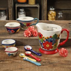 a wooden table topped with cups and spoons