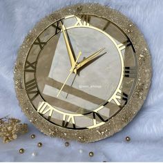 a clock with roman numerals on it sitting on a white fur covered surface