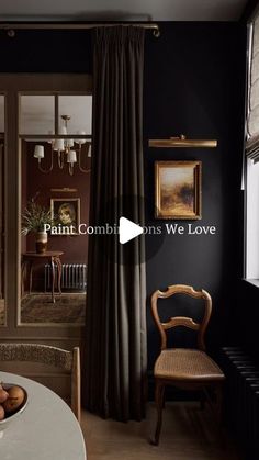 a dining room with black walls and white table in front of a window that reads paint comms we love