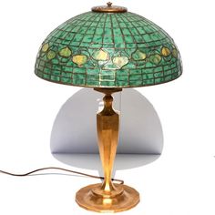 a green and gold lamp on a white background