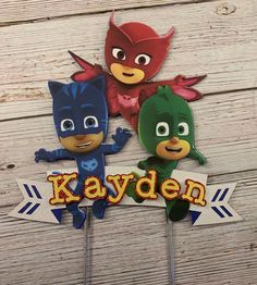 two cake toppers with the words kayden and pj masks on them