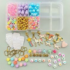 a plastic container filled with lots of different types of beads and charms on top of a table