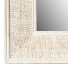 a white framed mirror sitting on top of a wall