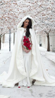 a woman dressed in white and holding a bouquet of flowers