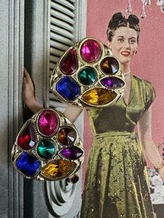 "80s Large Jewel Tone Gold Earrings. These earrings are so reminiscent of the 80s. They are a rounded corner triangular shape with seven jewel tone rhinestones . The colored stones are gold, purple, hot pink, green, red, blue , yellow. They measure 1 3/8\" in length and 1 3/8\" in width.  The earrings are lightweight since the base of the earrings are plastic. They are clip ons an the clips function well. Free Shipping in the U.S. when Purchasing $35 or more. Complementary Vintage Gift Wrap on t Jewel Tone Earrings, Vintage Jeweled Multicolor Earrings, 80's Earrings Vintage, 80s Earrings 1980s, Retro Multicolor Clip-on Earrings, 1980s Earrings, 80s Jewelry, 80s Earrings, 1980s Jewelry