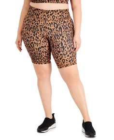 a plus size woman in leopard print shorts and cropped tank top with black sneakers