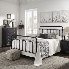 a bed room with a neatly made bed and dressers