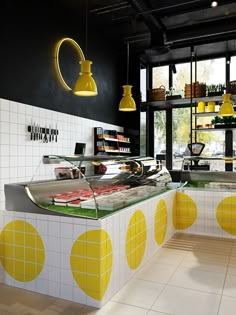 the interior of a deli with yellow and white polka dots on the walls, along with lights hanging from the ceiling