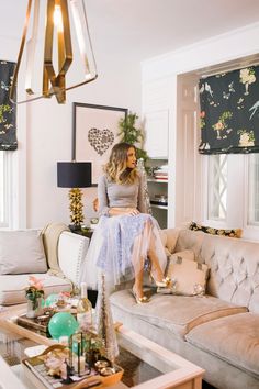 a woman sitting on top of a couch in a living room