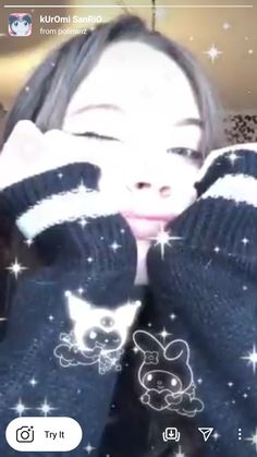 the girl is holding her hands up to her face while wearing knitted mittens