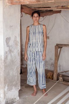 DETAILSThe Garima pant is an easy pull-on style with an elasticated waist with a contrasting hand braided drawcord, wide legs and a cropped length. MATERIALSIts eye catching pattern is achieved using a unique clamp dyed shibori technique to create a hand drawn like stripe pattern. We use natural indigo dyes to create a rich blue hue. Our naturally dyed kora fabric is an ideal weight for the summer and provides ease of wear throughout the warm season. With a unique hand feel due to the hand weavi Pant Designs Pattern, Shibori Outfit, Shibori Fashion, Shibori Clothing, Indigo Fashion, Shibori Dress, Fashion Over Fifty, Shibori Techniques, Natural Indigo Dye