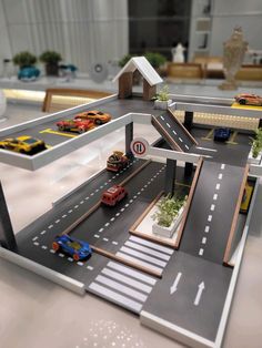 a model train station with cars and trucks on the tracks