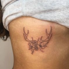 a woman's stomach with antlers and flowers on it