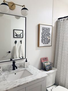 a bathroom with a sink, toilet and mirror