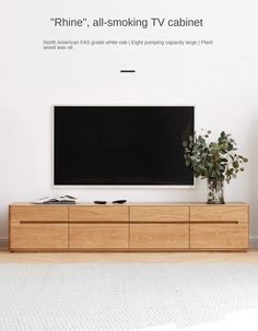 a flat screen tv sitting on top of a wooden cabinet in front of a white wall