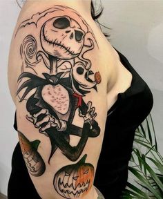 a woman with a skeleton tattoo on her arm holding a jack - o'- lantern