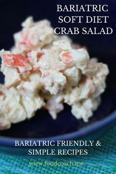 a blue bowl filled with crab salad on top of a green table cloth next to a spoon