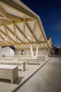 an empty outdoor seating area with white benches