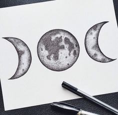 three drawings of the moon and earth on white paper with black marker pens next to it