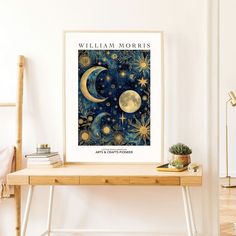 a poster with the words william morris on it next to a wooden table and potted plant