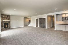 an empty living room with fireplace and cabinets