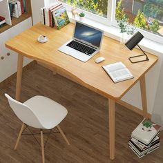 a laptop computer sitting on top of a wooden desk next to a white chair and books