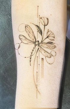 a tattoo on the leg of a woman's arm with flowers and leaves in it