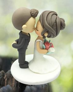 a wedding cake topper with a bride and groom kissing