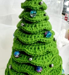 a green crocheted christmas tree sitting on top of a table