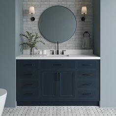 a bathroom with blue cabinets and a round mirror