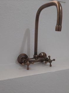 a faucet mounted to the side of a white wall