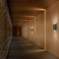 an empty hallway with wooden walls and lights