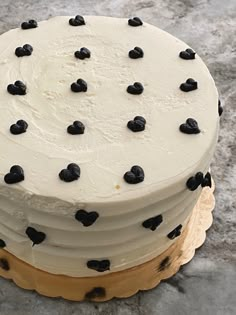 a cake with white frosting and black hearts on it