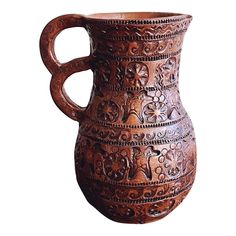 an ornately carved wooden pitcher on a white background