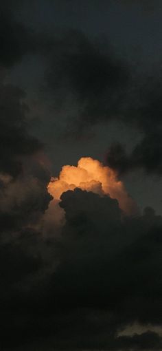 an orange cloud is in the dark sky