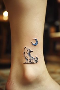 a small tattoo on the ankle of a woman's foot with a wolf and moon