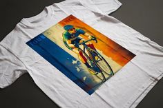 a white t - shirt with a painting of a man riding a bike on it