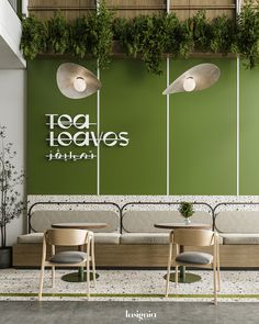 two chairs and a table in front of a green wall with plants growing on it