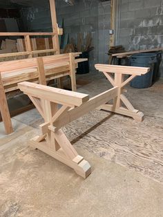 two wooden benches sitting next to each other on top of a cement floor in a building