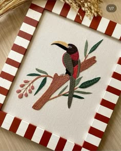 a red and black bird sitting on top of a tree branch next to some branches