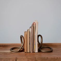 a stack of books sitting on top of a wooden table next to a pair of scissors