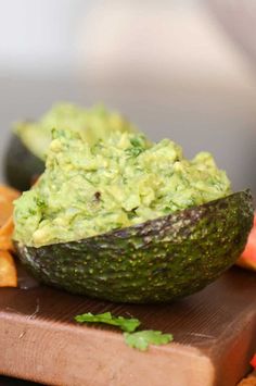 an avocado on a cutting board with chips