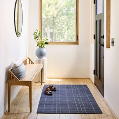 a pair of shoes sitting on top of a blue rug in front of a window