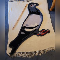 a bird is sitting on the edge of a pillow with scissors and thread next to it