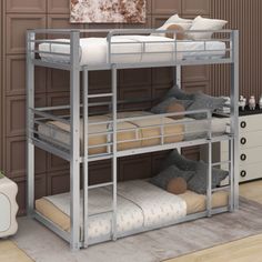 a metal bunk bed with two sets of mattresses on the bottom and one side