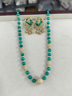 Add a touch of elegance to your jewelry collection with this stunning Emerald Bead Long Mala Necklace set, perfect for any special occasion or celebration. This exquisite piece of Indian and Pakistani jewelry features high-quality mala beads, carefully selected for their rich emerald color and lustrous shine. The necklace is adorned with sparkling Swarovski Kundan stones, creating a striking statement look. Accompanied by elegant CZ stud earrings, this set is ideal for weddings, parties, or trad Elegant Green Polished Beads, Formal Festive Beaded Necklaces With Round Beads, Formal Festive Necklace With Round Beads, Formal Festive Beaded Necklace With Round Beads, Elegant Emerald Necklace With Beaded Chain, Celebration Pearl Necklace With Gemstone Beads, Elegant Beaded Necklace For Festive Season, Elegant Beaded Chain Bridal Necklace For Festive Occasion, Elegant Festive Beaded Necklaces